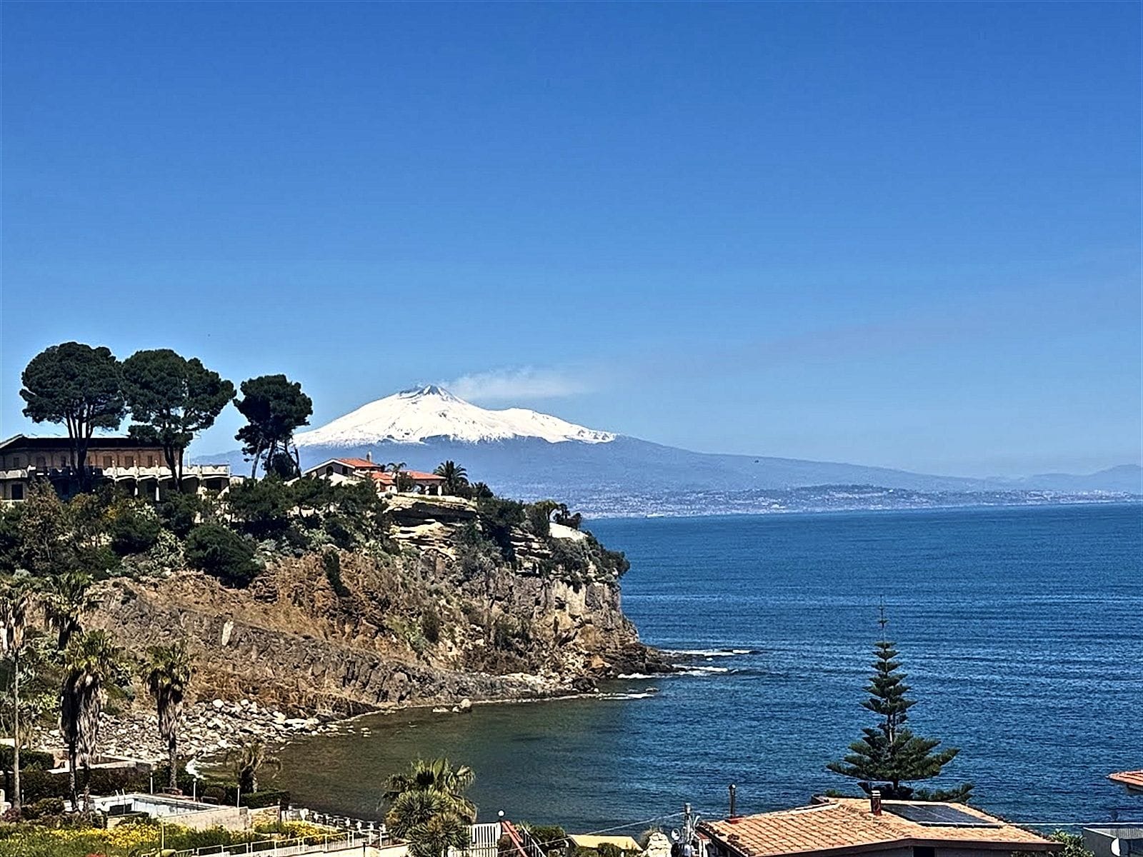 L'Etna innevato oltre il mare della Baia del Gambero