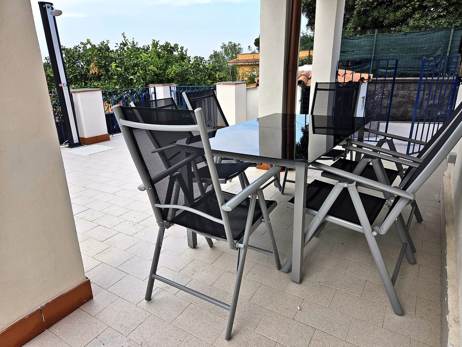 Tavolo e sedie da esterno sotto la veranda coperta, affacciati sulla terrazza